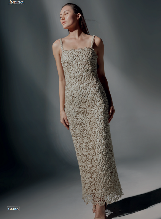 Modelo de frente luciendo el Vestido Andrea largo de crochet color beige, con tirantes finos y tejido de flores, en un estudio de estilo minimalista.